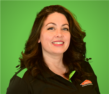 Female SERVPRO Employee smiling in front of a green background.